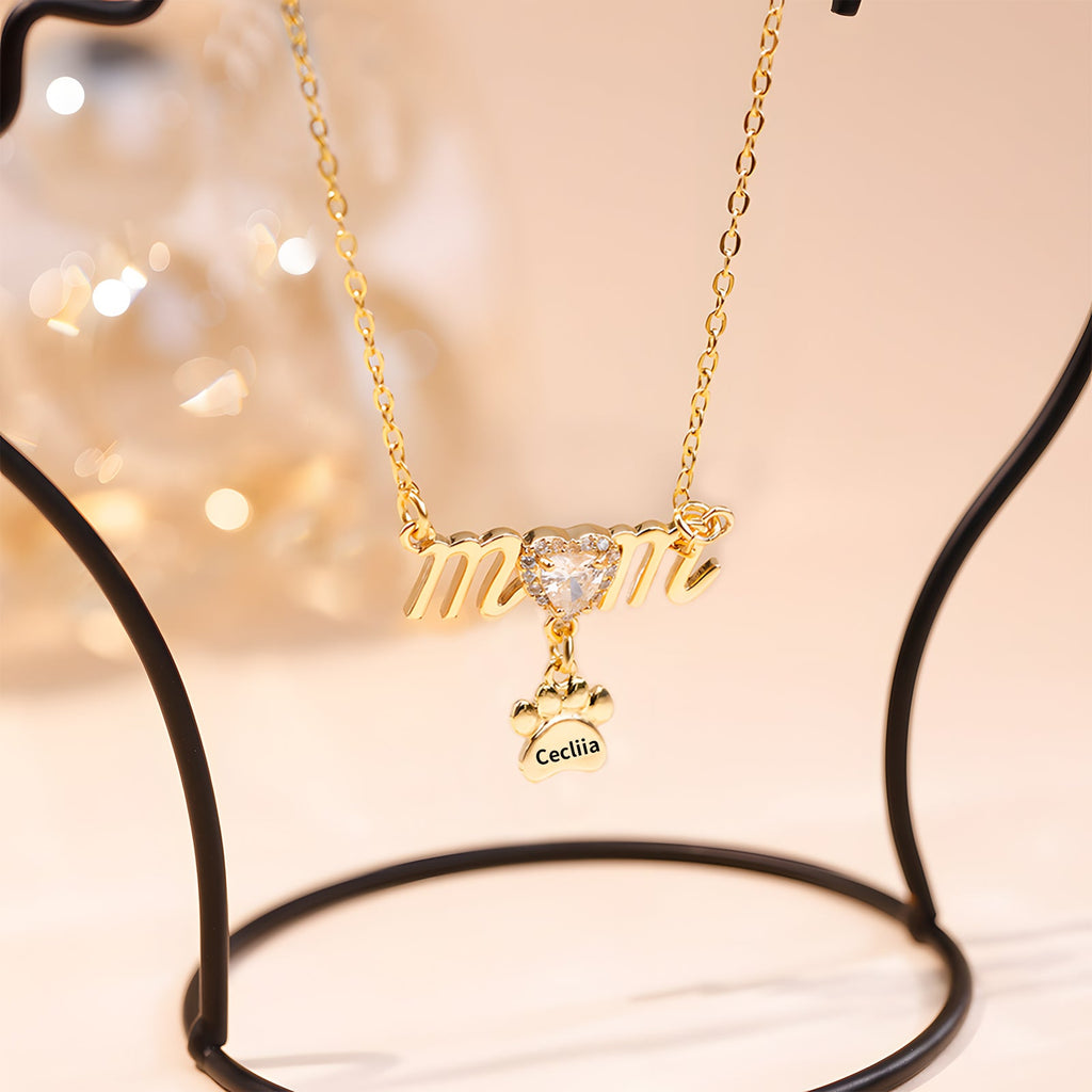 Gold Mother's Day necklace with paw print charm and sparkling heart detail.