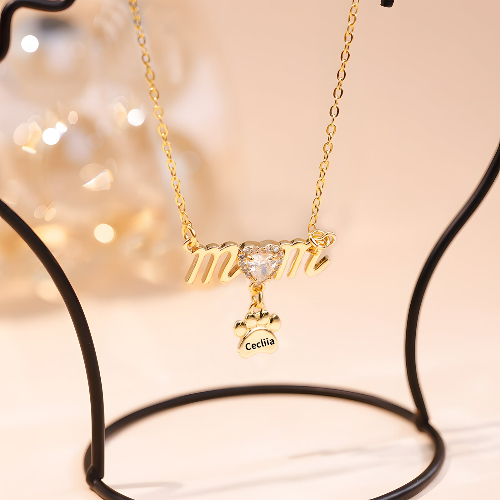 Gold Mother's Day necklace with paw print charm and sparkling heart detail.